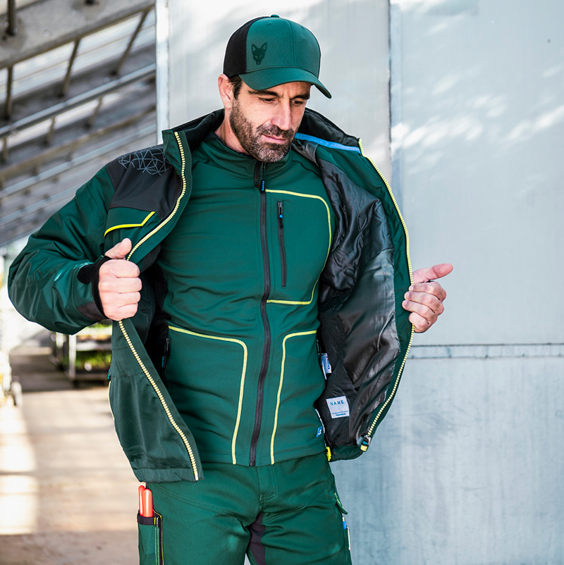 Ouvrier portant une veste d'hiver verte, une couche intermédiaire et une casquette de baseball