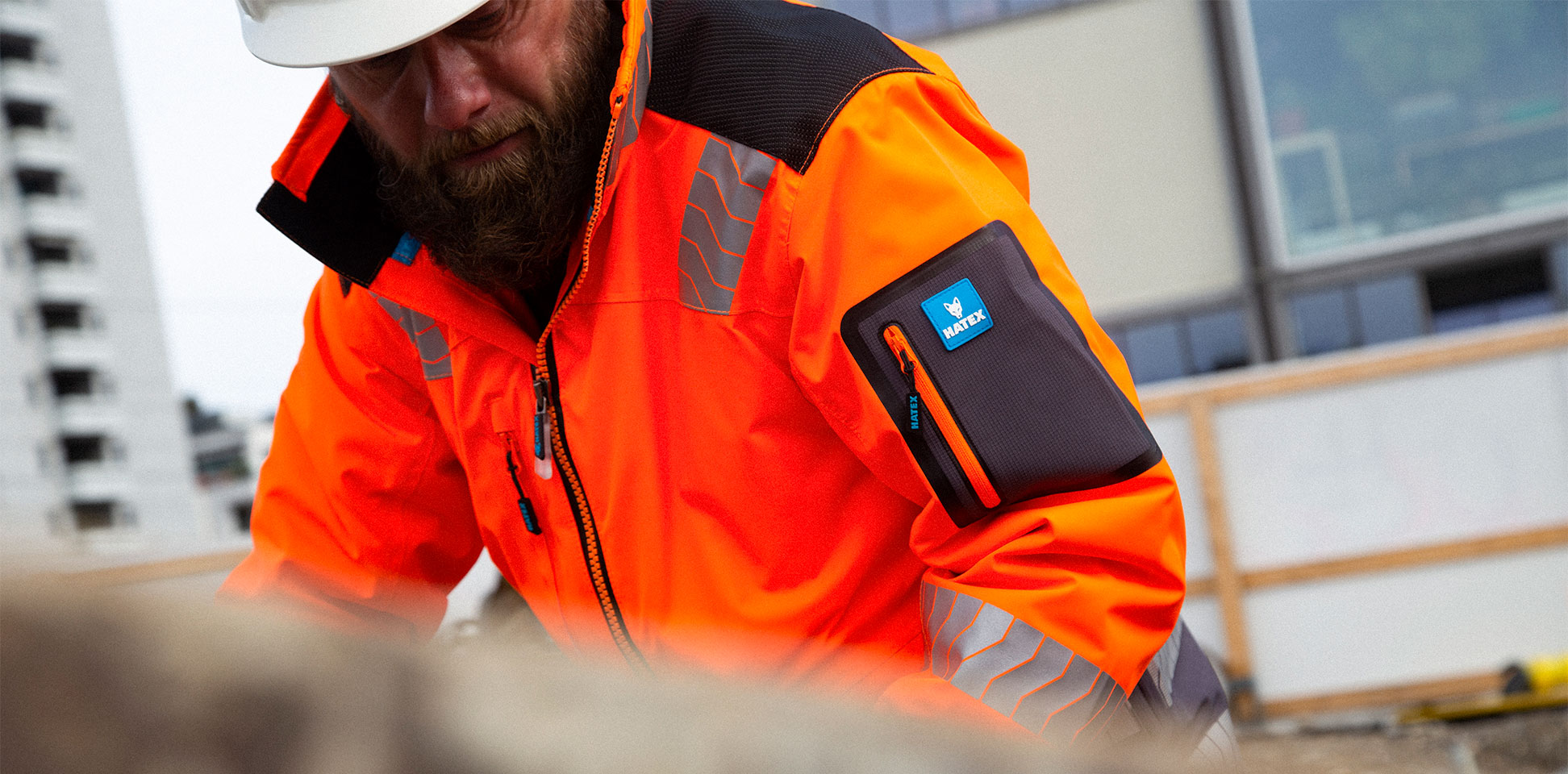 Travailleur sur un chantier avec pantalon de travail et veste de sécurité